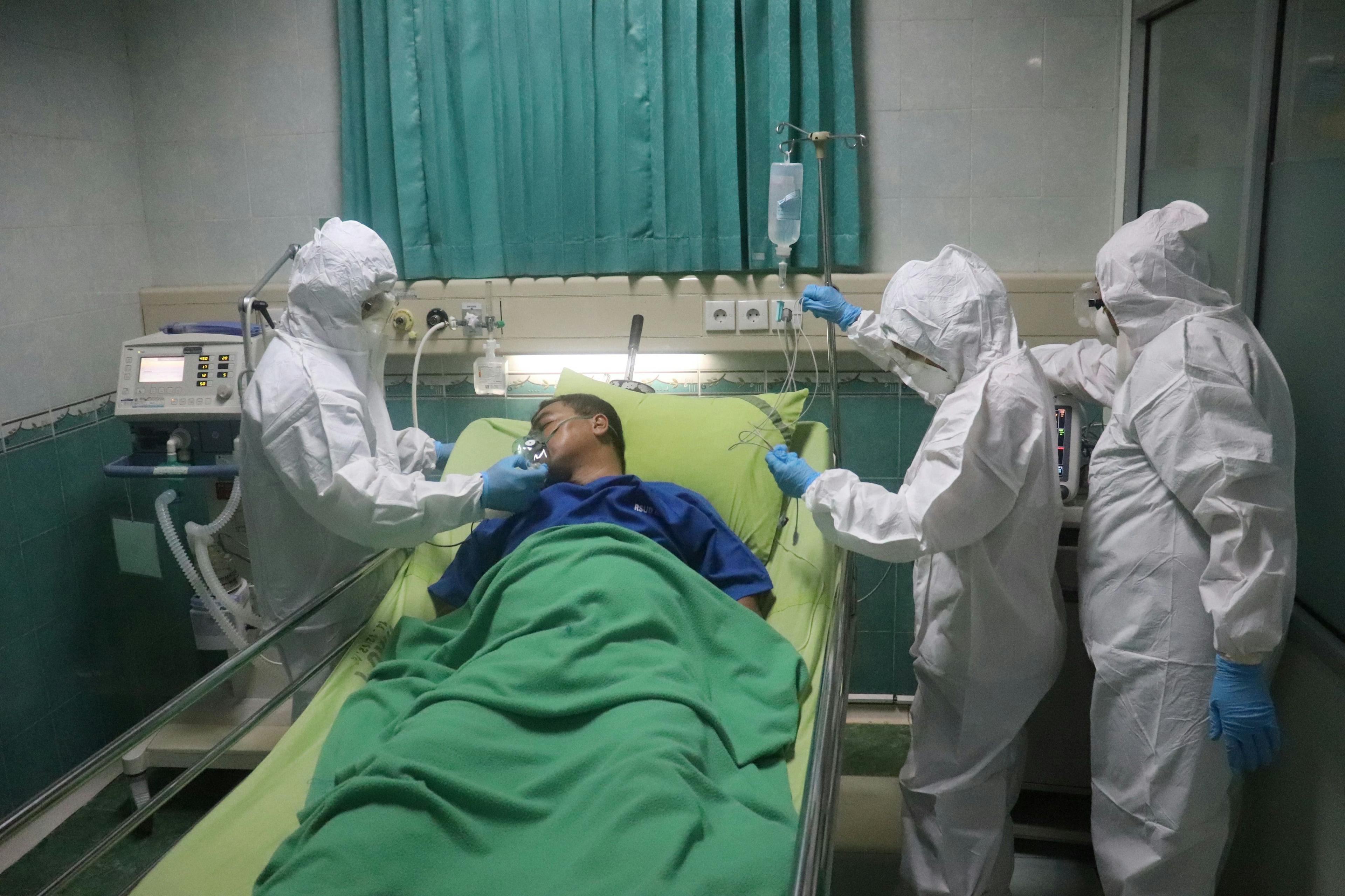 a team of providers caring for a man in the ICU